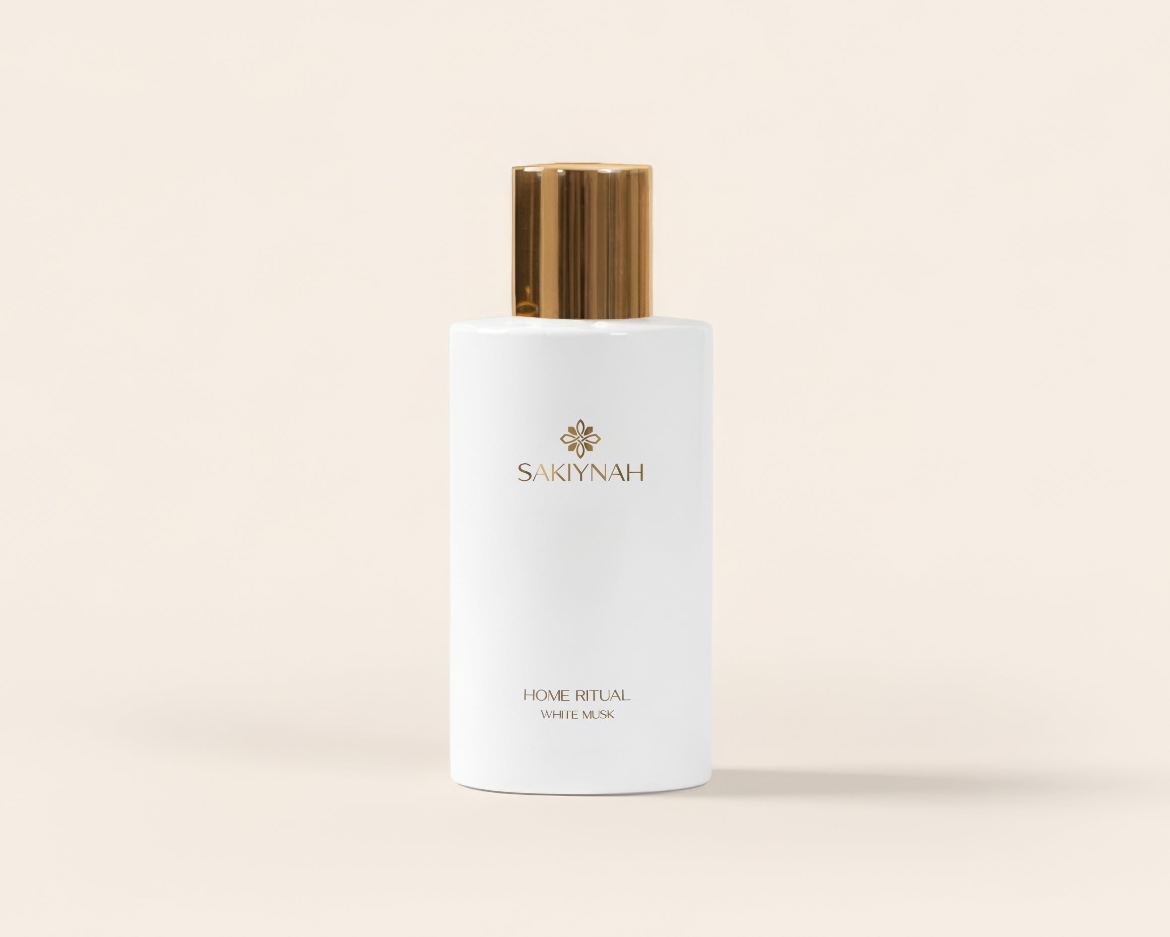 Hand holding a white skincare bottle with gold cap against a blurred lights background